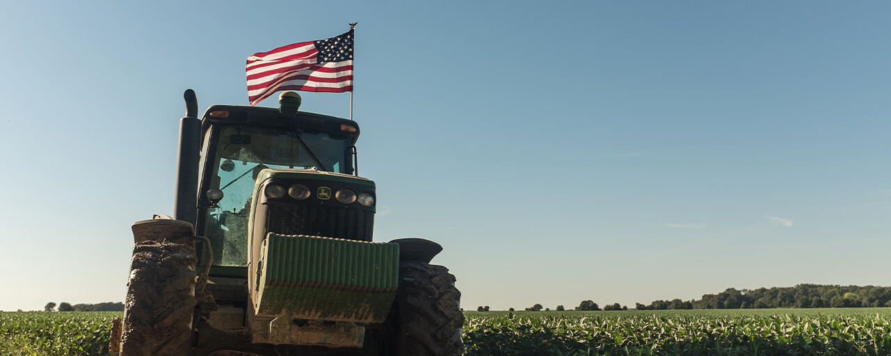 Tractor on a Farm with a waving American flag.